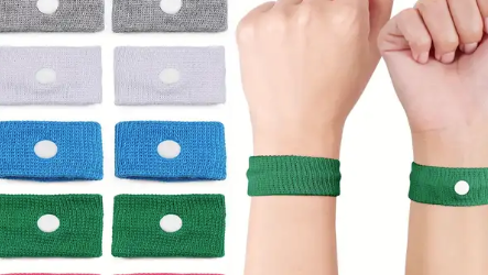 Grey, blue and green seasickness bands, with a wrist showing how to wear the band to avoid seasickness